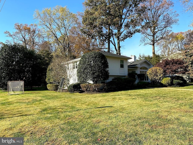 view of property exterior with a yard and a chimney