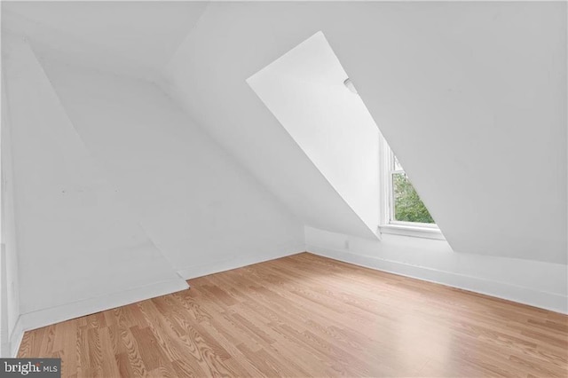 bonus room with lofted ceiling and light wood-style floors