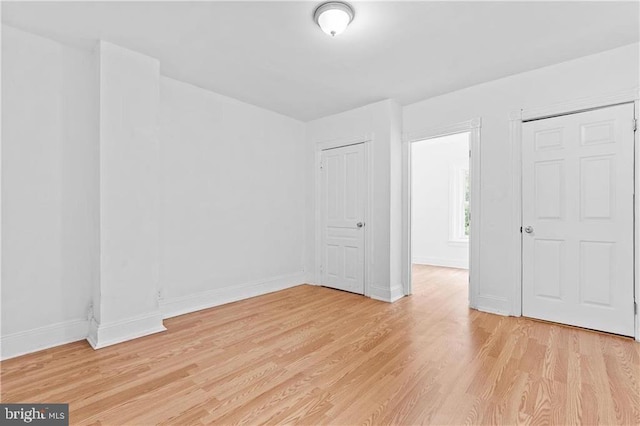 unfurnished bedroom featuring light wood-style floors and baseboards