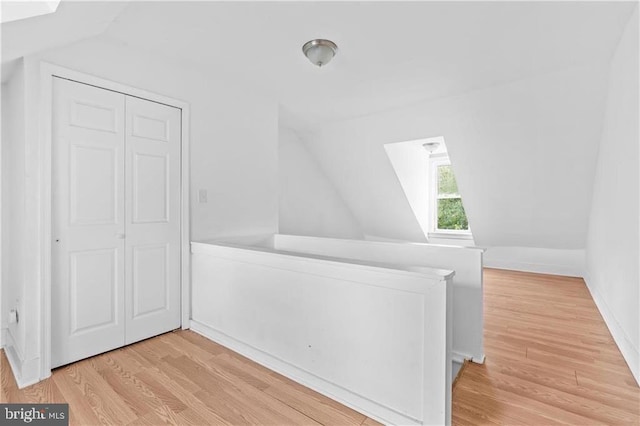 bonus room with light wood-type flooring and lofted ceiling