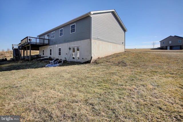 rear view of property with a lawn, a deck, and french doors