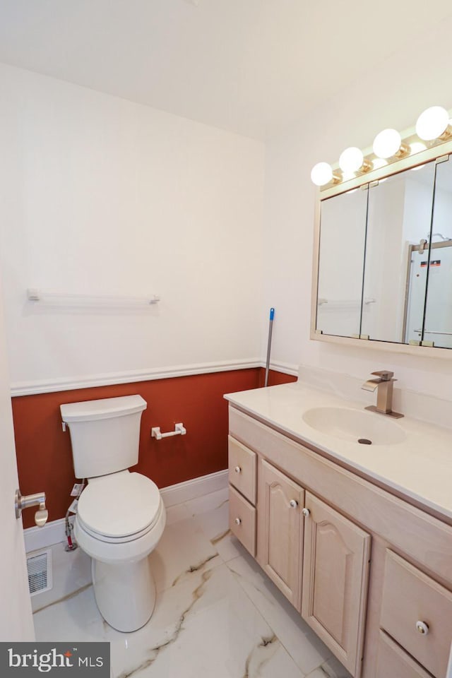 bathroom with baseboards, visible vents, toilet, marble finish floor, and vanity