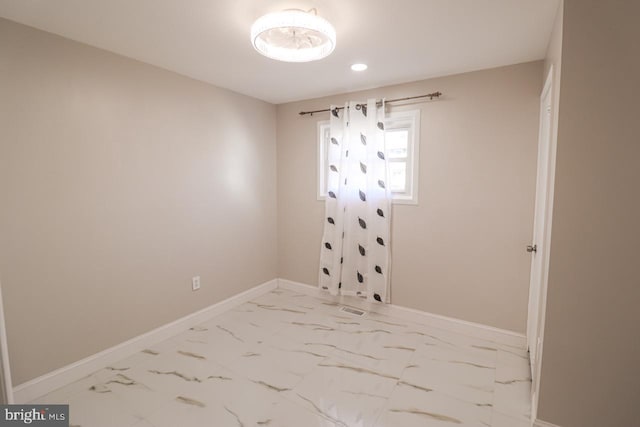 spare room with marble finish floor and baseboards