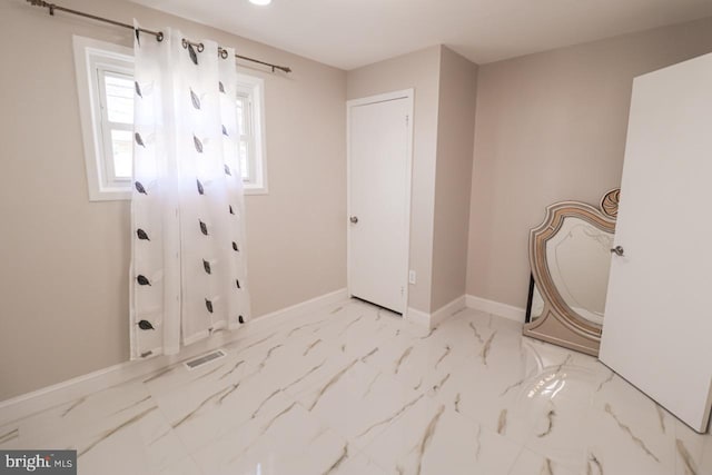 clothes washing area with marble finish floor, visible vents, and baseboards