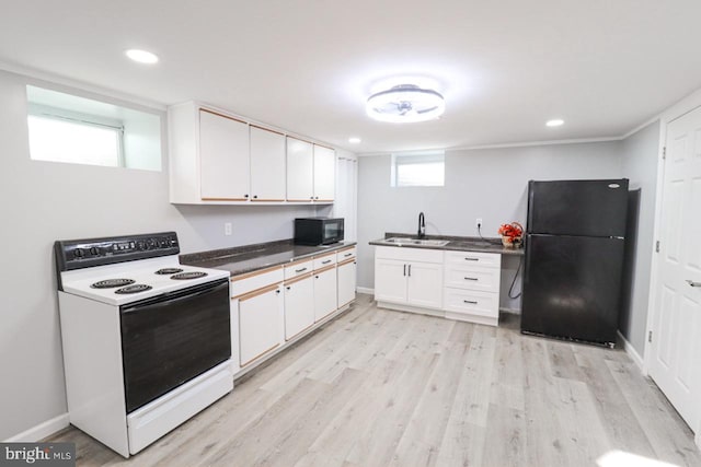 kitchen with dark countertops, light wood-style flooring, black appliances, white cabinetry, and a sink