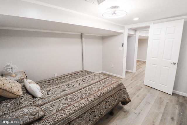 bedroom with light wood finished floors and baseboards