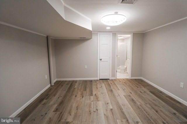 finished below grade area featuring ornamental molding, wood finished floors, and baseboards