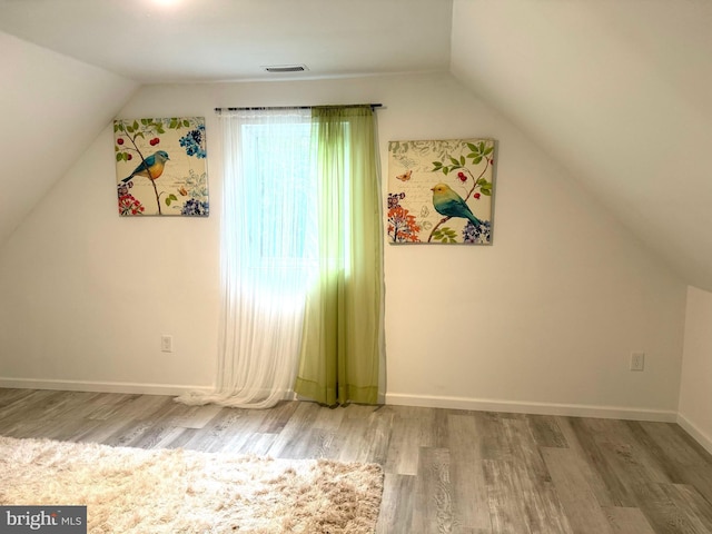 bonus room featuring lofted ceiling and hardwood / wood-style floors