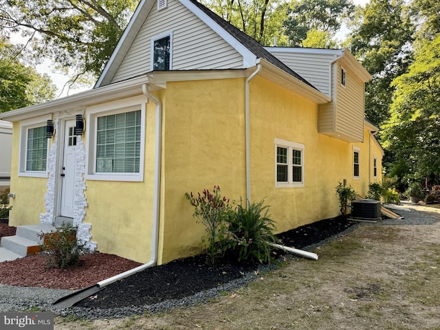 view of side of home with central AC