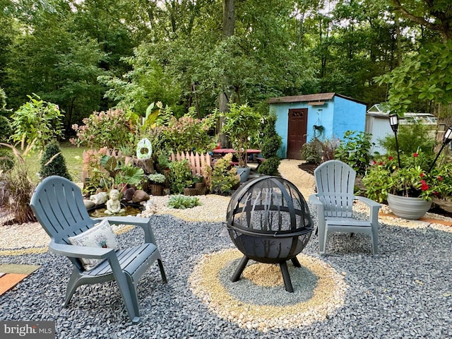 view of patio / terrace featuring a storage unit and a fire pit