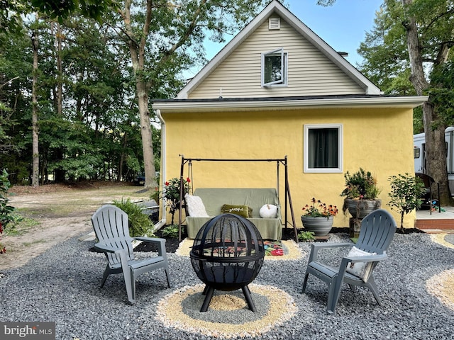 back of house with an outdoor fire pit