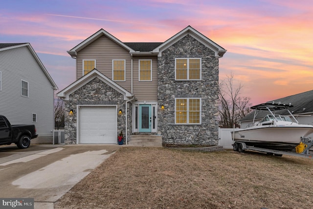 traditional home with driveway, stone siding, a garage, and a yard