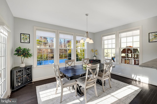 dining area featuring dark wood-style flooring and baseboards