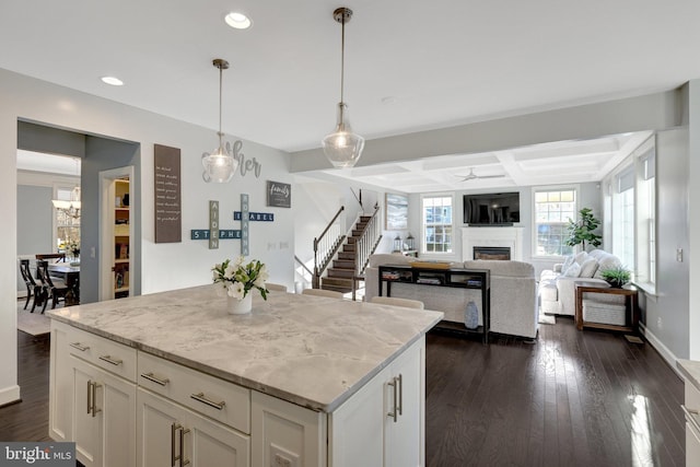 kitchen with dark wood-style flooring, coffered ceiling, a fireplace, and white cabinets