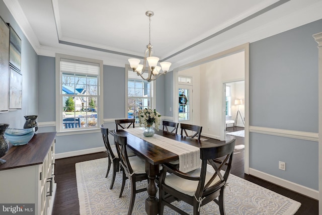 dining area with a chandelier, baseboards, ornamental molding, dark wood-style floors, and a tray ceiling