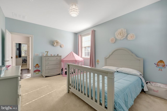 bedroom with baseboards, visible vents, and light colored carpet