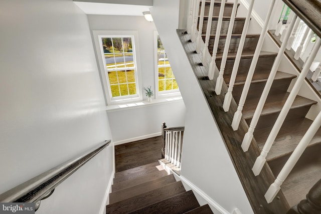 stairway featuring baseboards and wood finished floors