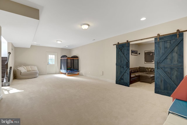 living area featuring a barn door, baseboards, carpet flooring, and recessed lighting