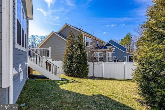 exterior space with stairway, fence, and a yard