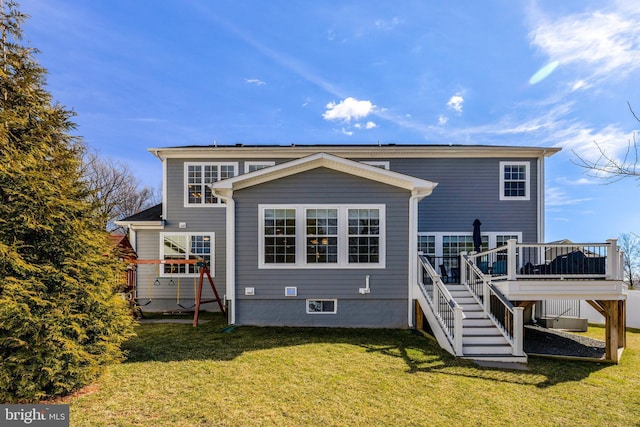 back of property with stairs, a deck, and a yard