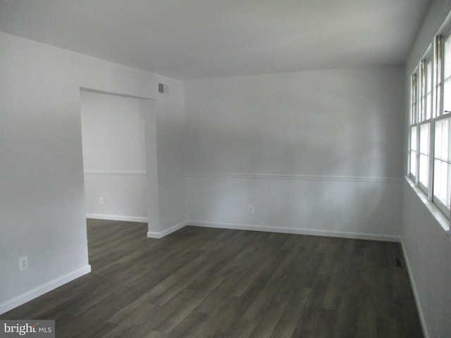 spare room featuring dark wood-type flooring