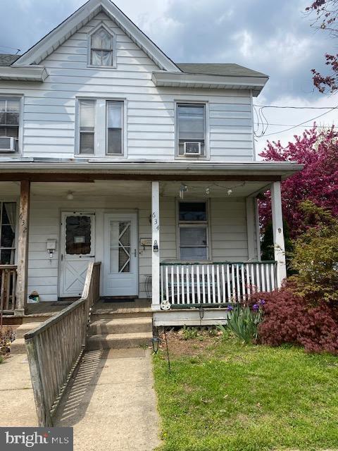 view of front of property featuring cooling unit and a front lawn