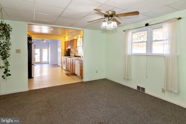 interior space with ceiling fan and a drop ceiling