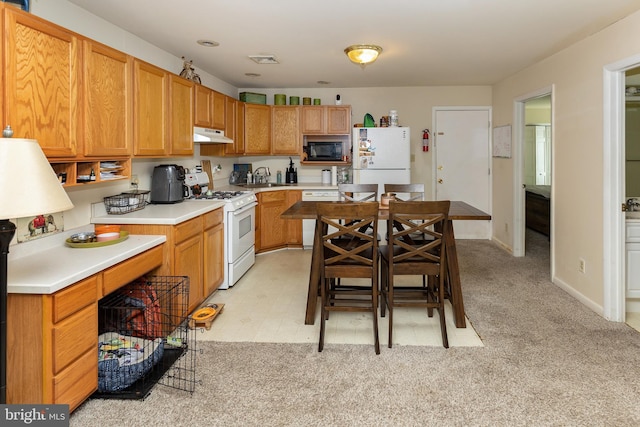 kitchen featuring sink, light carpet, and white appliances