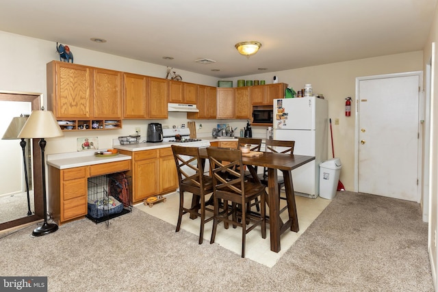 kitchen with black microwave, white refrigerator, and range