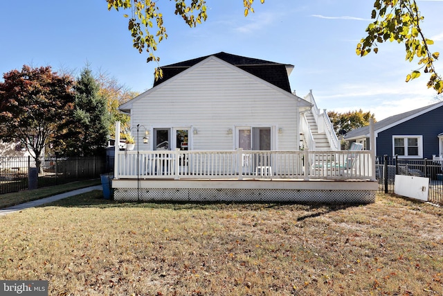 rear view of house with a deck and a lawn