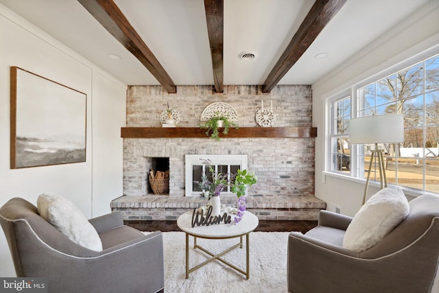 living room featuring beam ceiling and a fireplace