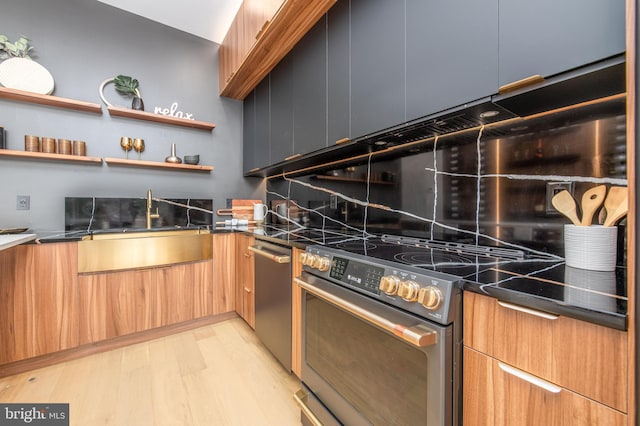 217 Tasker St, Philadelphia, PA 19148 - kitchen featuring dark countertops, backsplash, light wood-style flooring, modern cabinets, and stainless steel electric range