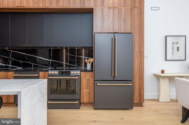 217 Tasker St, Philadelphia, PA 19148 - kitchen featuring appliances with stainless steel finishes, light wood-style floors, decorative backsplash, and modern cabinets