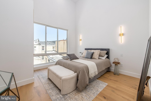 217 Tasker St, Philadelphia, PA 19148 - bedroom with baseboards, a towering ceiling, and light wood-style floors