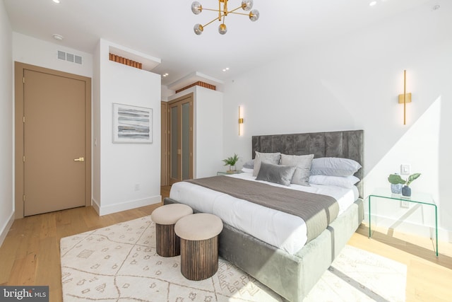 217 Tasker St, Philadelphia, PA 19148 - bedroom with an inviting chandelier, wood finished floors, visible vents, and baseboards