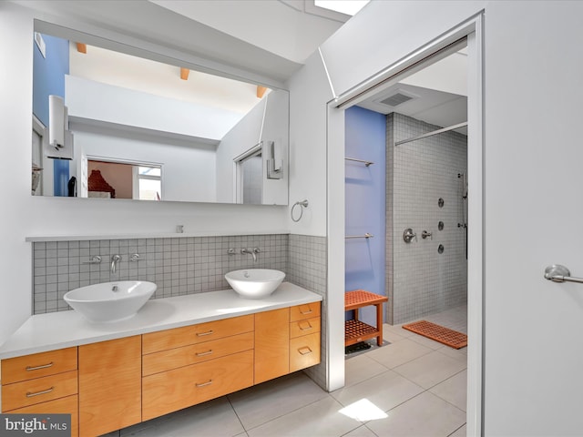 full bathroom featuring tile patterned flooring, visible vents, tiled shower, and a sink