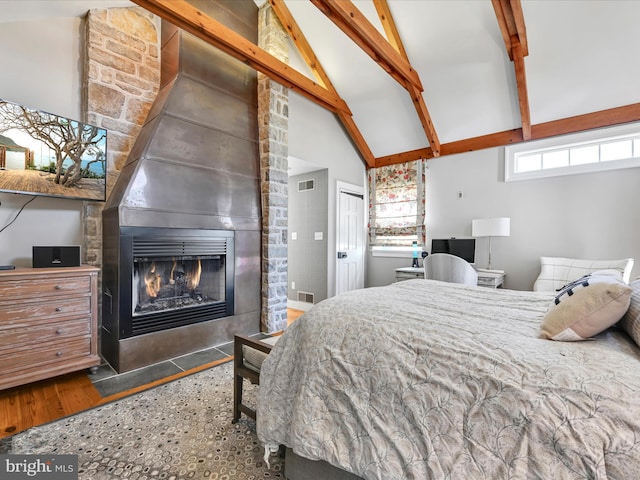 bedroom featuring visible vents, beam ceiling, a fireplace, a closet, and high vaulted ceiling