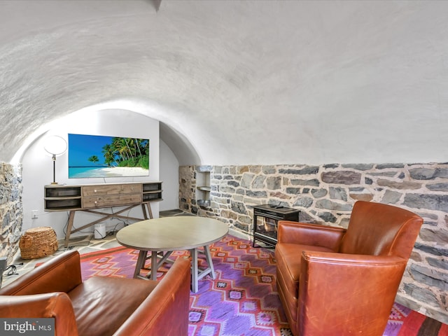 living area featuring a wood stove and lofted ceiling