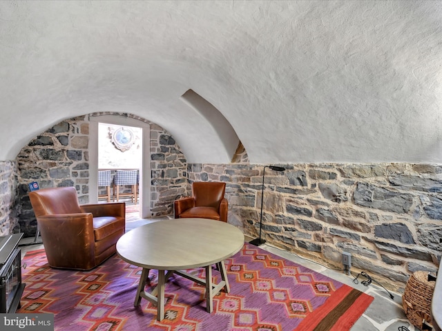 living area featuring a textured ceiling and vaulted ceiling