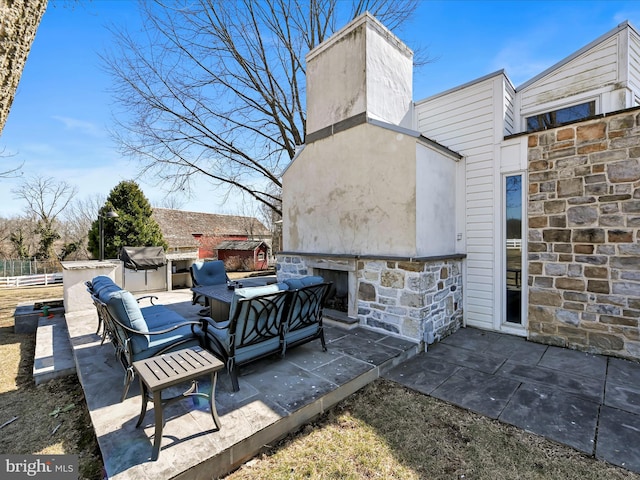 view of patio featuring an outdoor living space with a fireplace