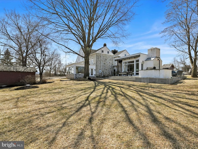 rear view of property featuring a lawn