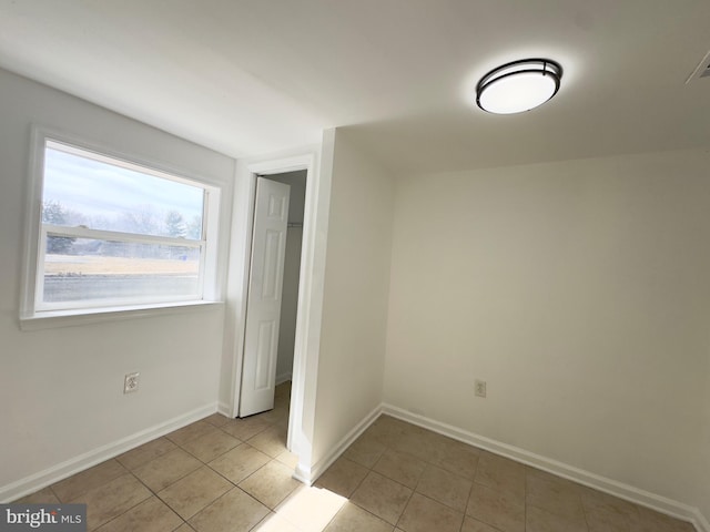 unfurnished bedroom featuring baseboards and light tile patterned floors