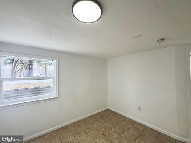 tiled spare room with visible vents and baseboards