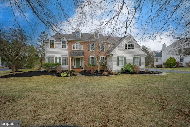 view of front facade featuring brick siding and a front yard