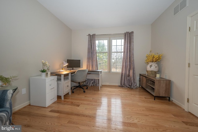 office with vaulted ceiling, light wood finished floors, visible vents, and baseboards