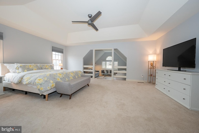 bedroom with light carpet, a raised ceiling, a ceiling fan, and lofted ceiling