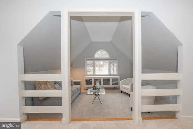 living area featuring vaulted ceiling, carpet flooring, and baseboards