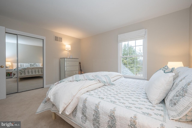 carpeted bedroom featuring visible vents and a closet