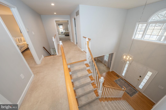 carpeted foyer entrance featuring a chandelier, recessed lighting, visible vents, and baseboards