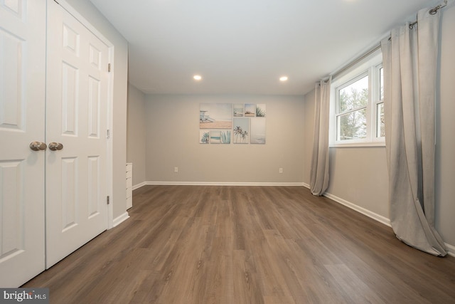 spare room featuring recessed lighting, wood finished floors, and baseboards